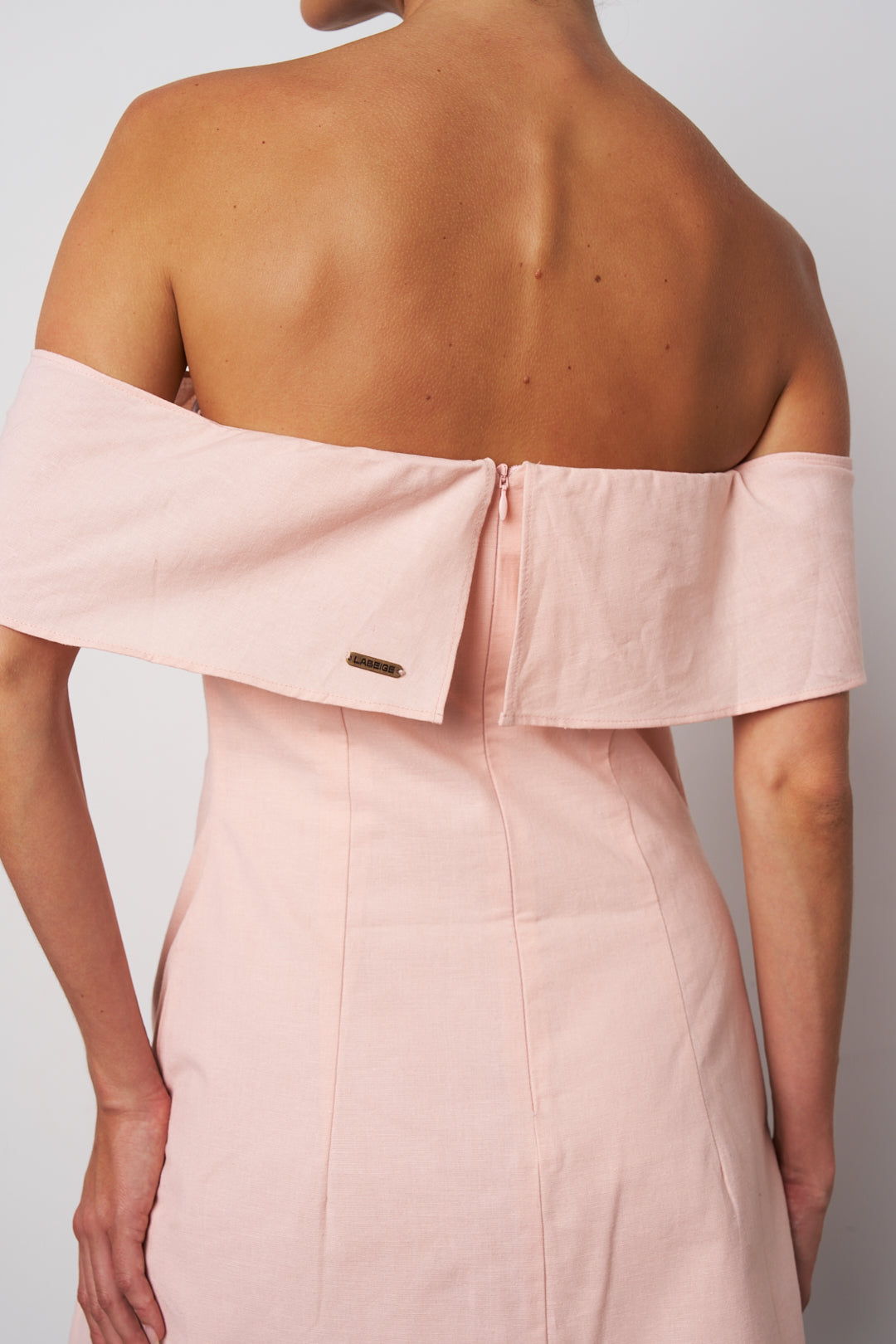 Pink off-shoulder dress with a plain background