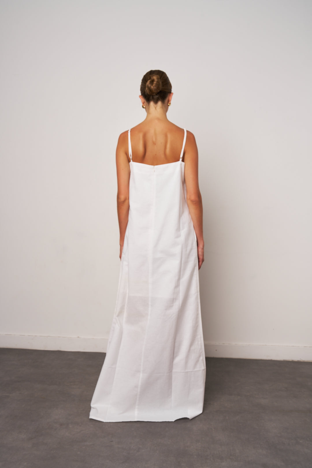 Woman wearing a white dress against a plain background