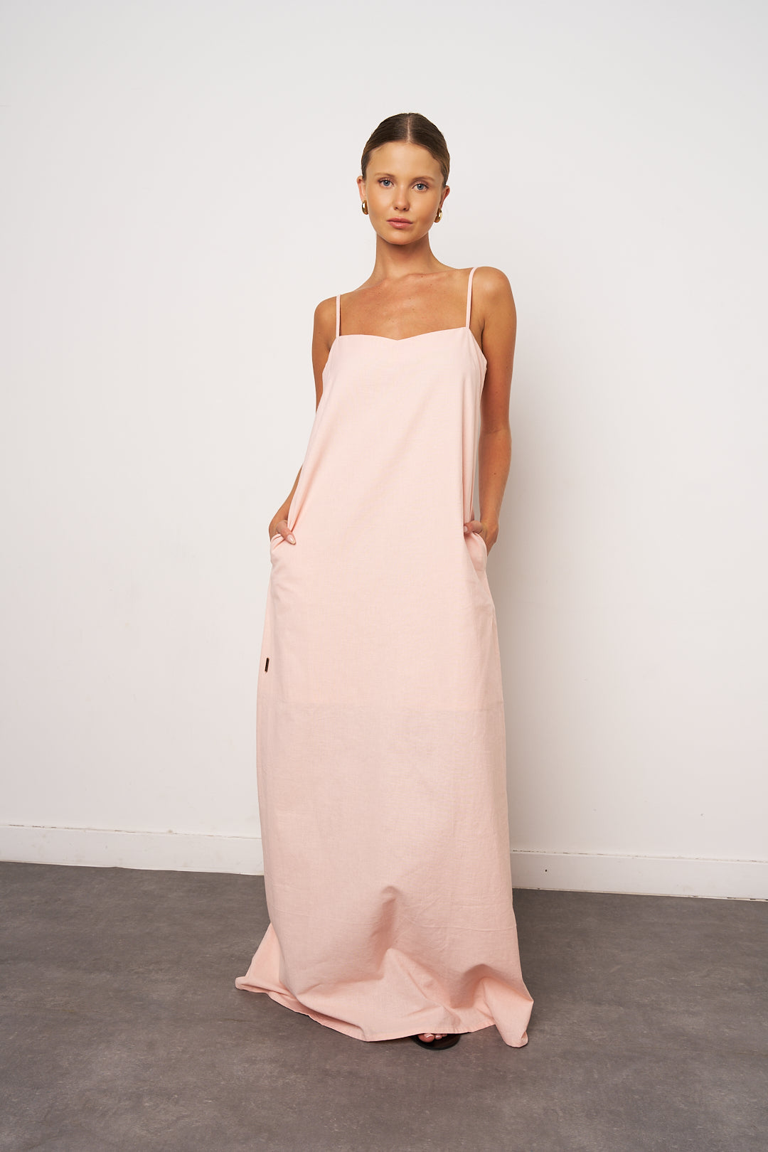 Woman wearing a long pink dress against a white background