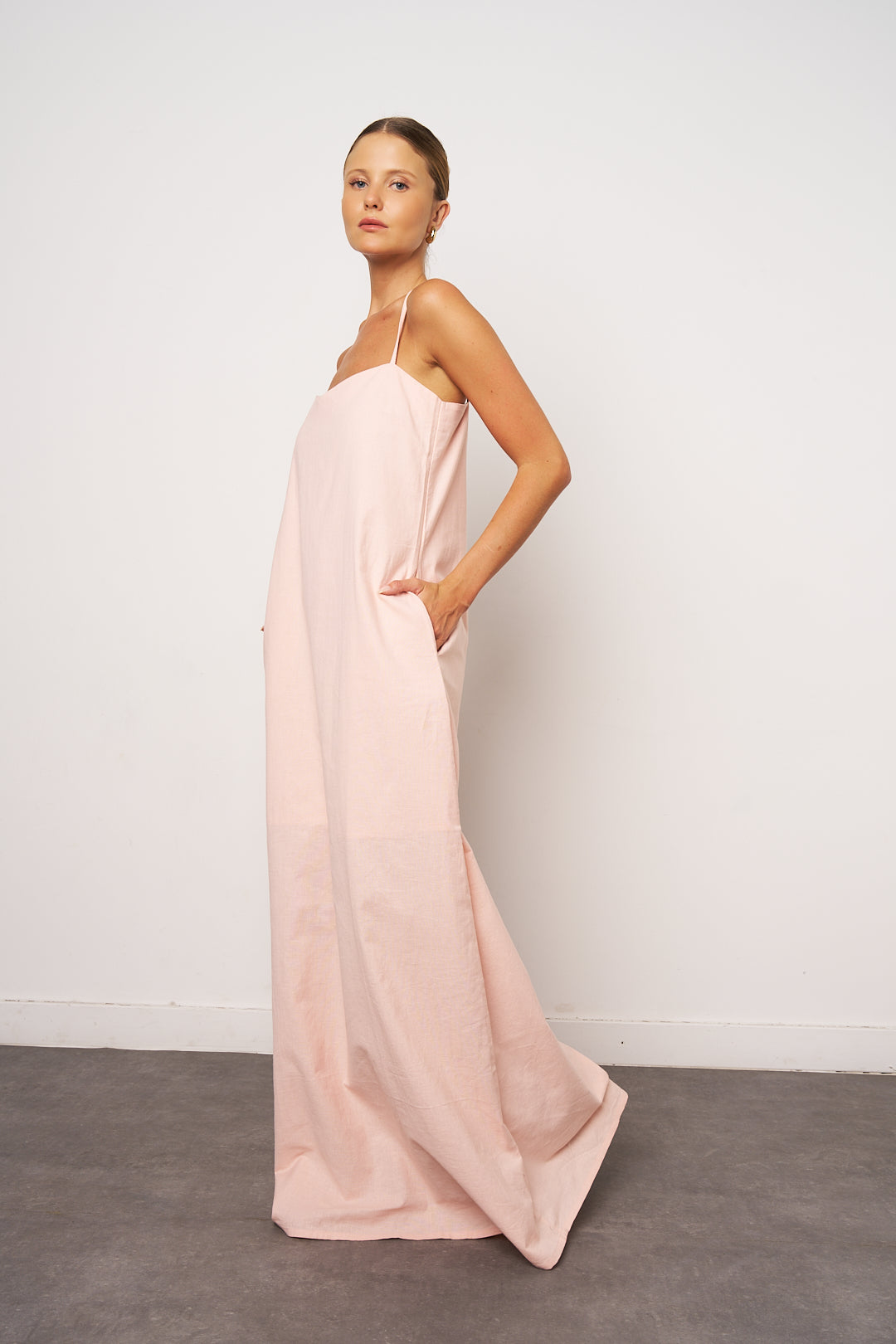 Woman wearing a long pink dress against a white background