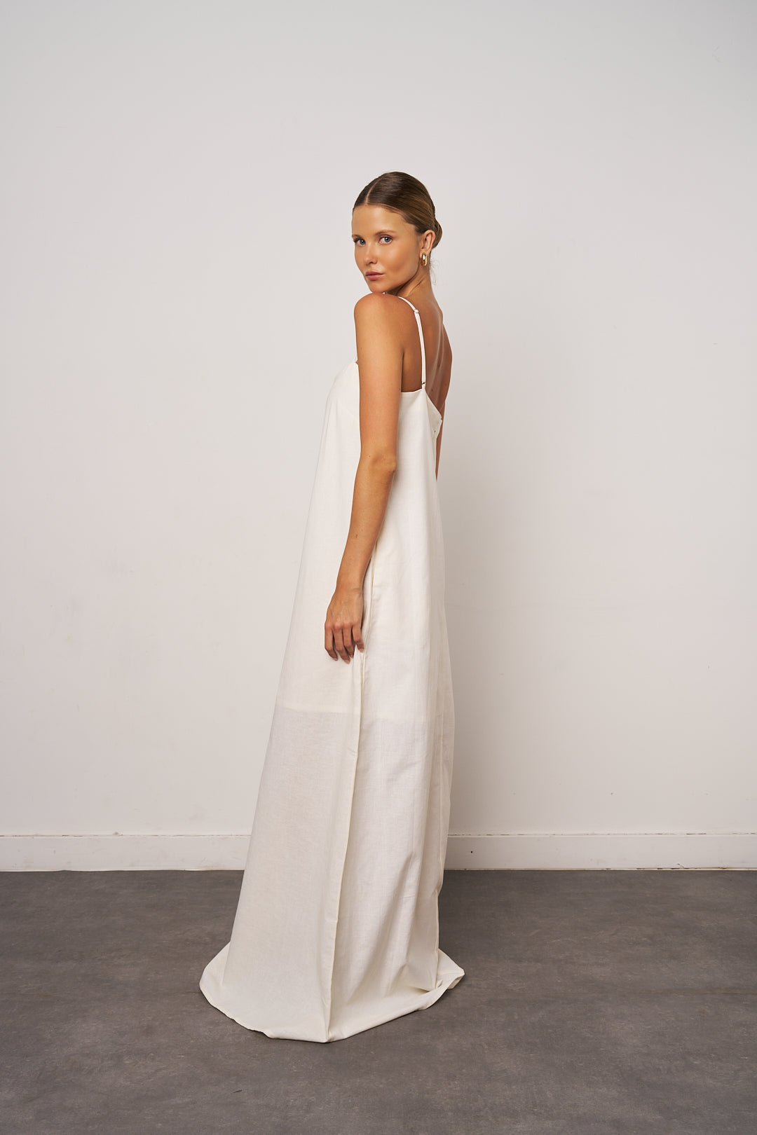 Woman wearing a white dress against a plain background