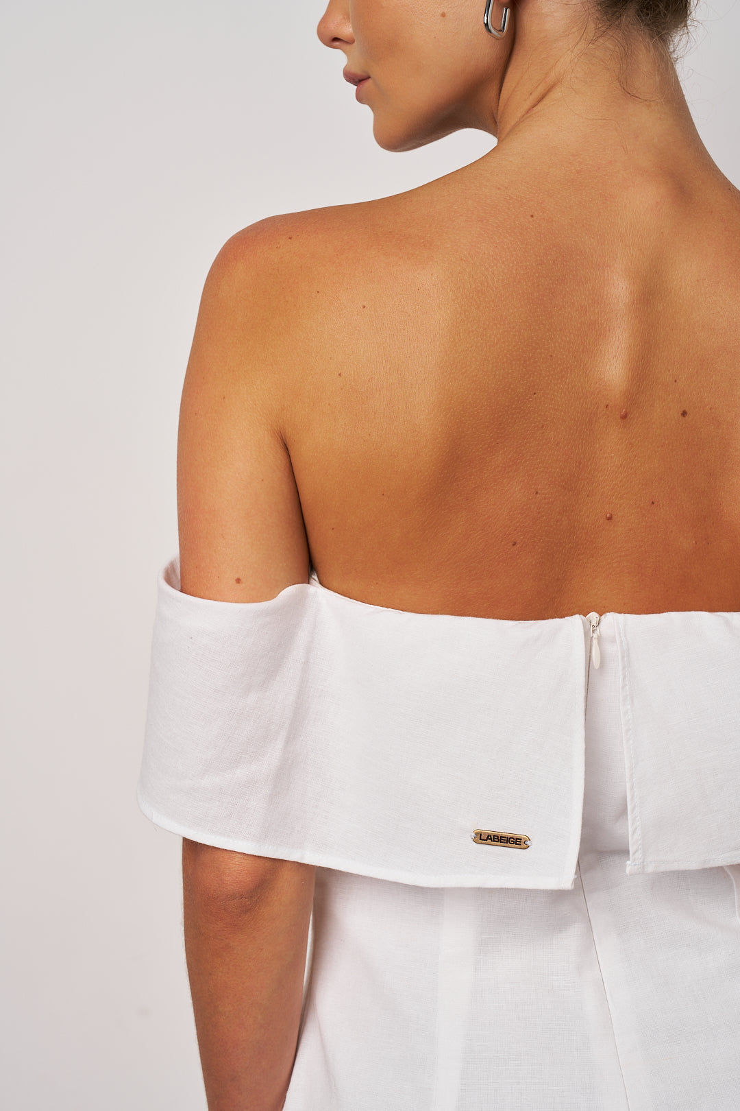 White off-shoulder top on a plain background