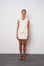 Woman wearing a cream-colored dress against a white background