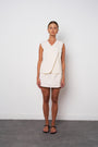 Woman wearing a cream-colored dress against a white background