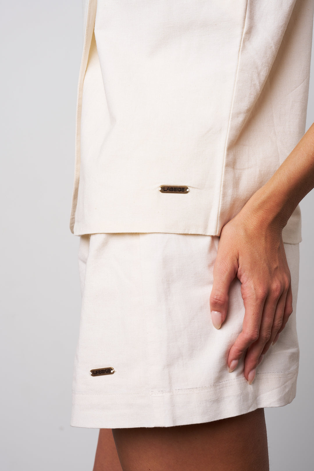 White suit with gold buttons on a plain background