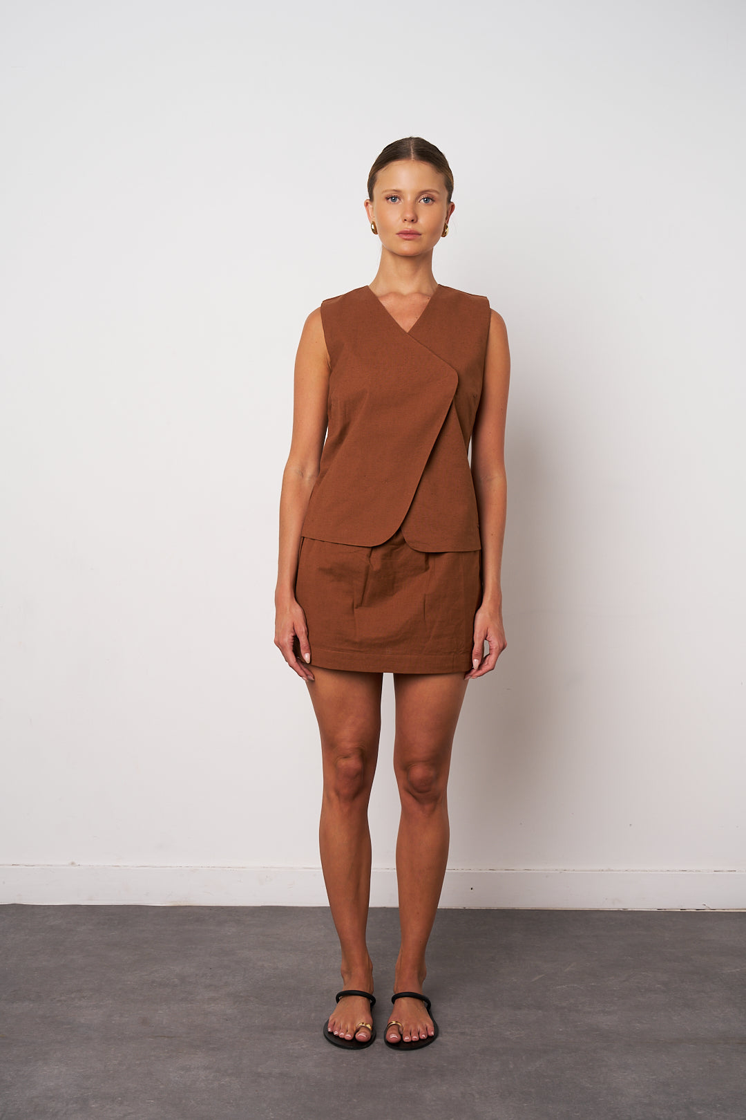 Woman wearing a brown dress against a white background