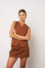 Woman wearing a brown dress with a plain background