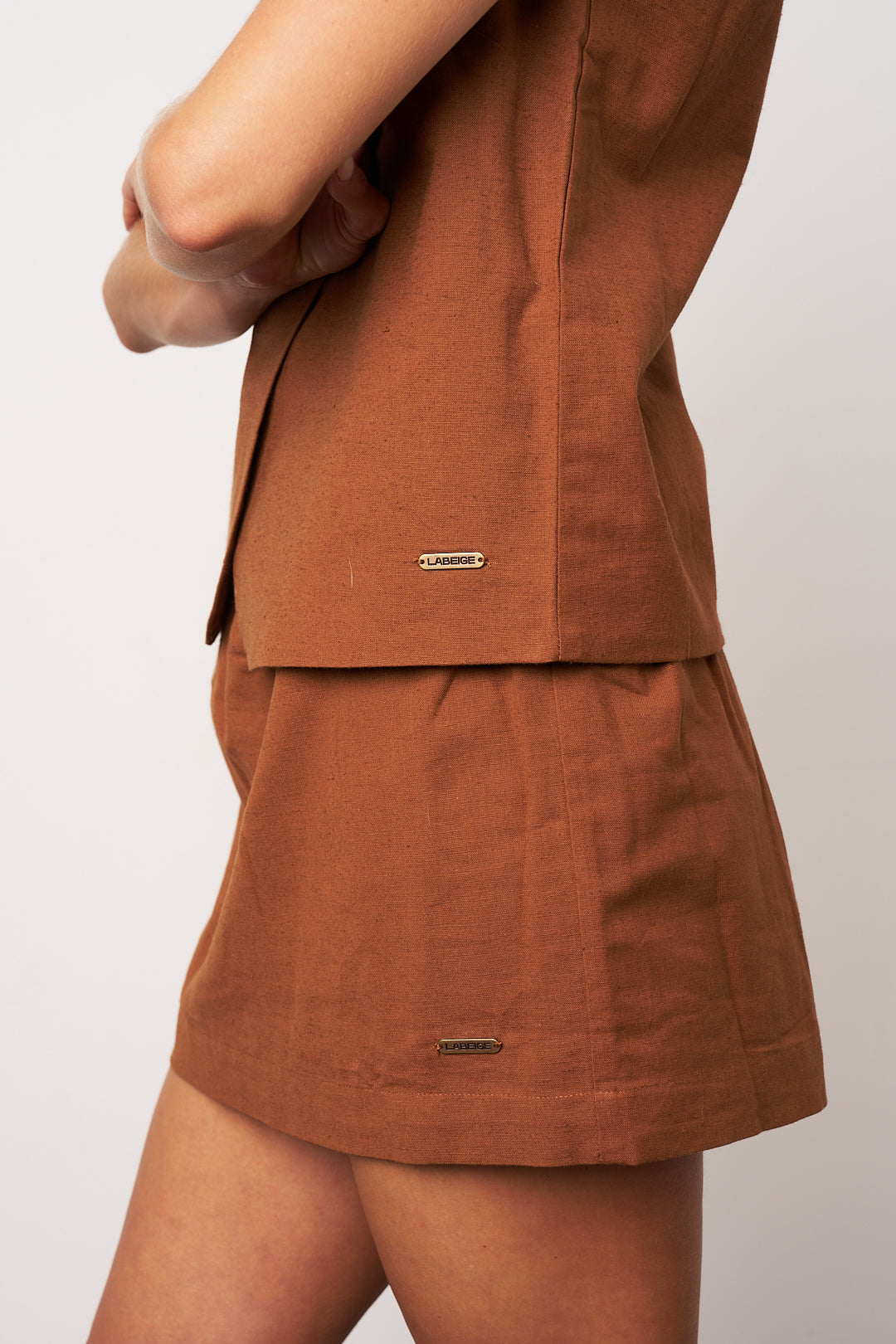 Brown shorts with a matching jacket on a plain background