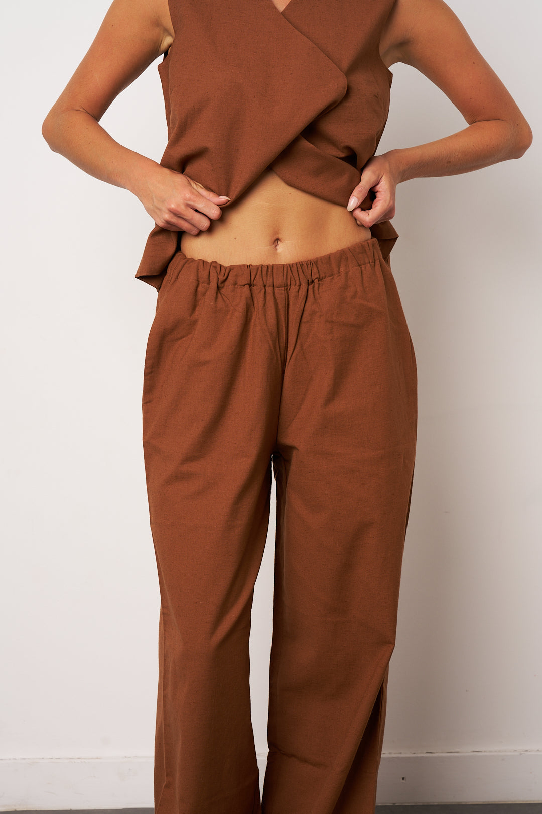 Brown outfit with a top and pants against a white background