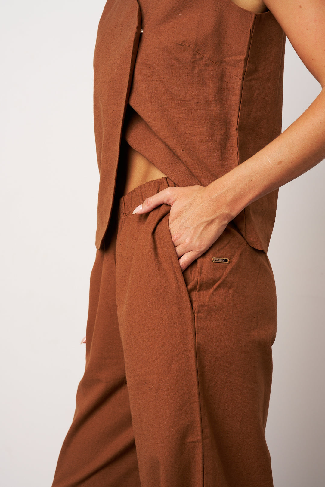 Brown outfit with a jacket and pants on a plain background