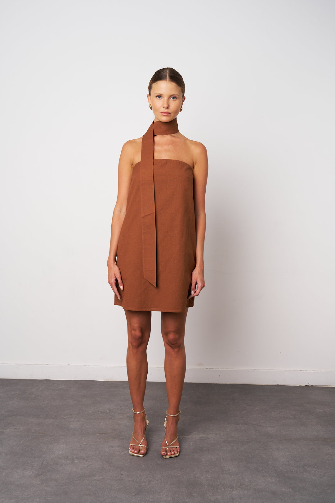 Woman wearing a brown dress against a white background