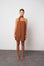 Woman wearing a brown dress against a white background