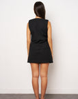 Person wearing a black sleeveless dress against a white background