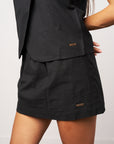 Black suit with a jacket and skirt on a plain background