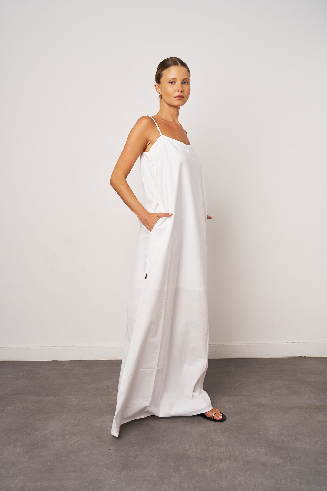 Woman wearing a white dress against a plain background